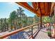 Enjoy this wood deck with metal cable railing overlooking the forest and hillside scenery at 24929 N Mountain Park Dr, Evergreen, CO 80439