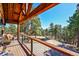 Relax on the wood deck with cable railing and enjoy the view of the surrounding forest at 24929 N Mountain Park Dr, Evergreen, CO 80439
