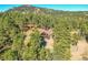 A stately home surrounded by mature trees with a stone facade and upper level deck at 24929 N Mountain Park Dr, Evergreen, CO 80439