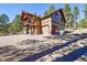 Charming exterior showcasing stone accents, a balcony, and a well-maintained two-car garage at 24929 N Mountain Park Dr, Evergreen, CO 80439