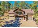 Stately home with stone facade and charming pink front door with outdoor seating at 24929 N Mountain Park Dr, Evergreen, CO 80439