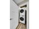 Convenient laundry room featuring stacked washer and dryer with wood-look floors at 24929 N Mountain Park Dr, Evergreen, CO 80439