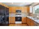 Well-equipped kitchen with wood cabinets, granite countertops, and stainless-steel appliances at 882 W 96Th Ave, Thornton, CO 80260
