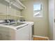 Bright laundry room with modern washer and dryer, plus overhead storage, and a window at 882 W 96Th Ave, Thornton, CO 80260