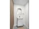 Modern powder room with a floating vanity, arched mirror, and stylish accent wall at 2276 Newland St, Edgewater, CO 80214