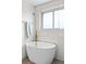 Relaxing soaking tub with gold fixtures next to a window, offering a tranquil atmosphere at 2276 Newland St, Edgewater, CO 80214