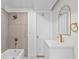 Bathroom with white vanity, gold fixtures, and a tiled shower, creating a clean and stylish space at 2276 Newland St, Edgewater, CO 80214