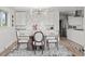 Bright dining area featuring modern lighting, a glass-top table, and stylish chairs, with kitchen view at 2276 Newland St, Edgewater, CO 80214