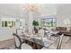 Bright dining area featuring modern lighting, a glass-top table, and stylish chairs, with living room view at 2276 Newland St, Edgewater, CO 80214