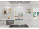 Well-lit kitchen with modern cabinets, floating shelves, stainless steel appliances, and stylish fixtures at 2276 Newland St, Edgewater, CO 80214