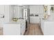 Modern kitchen with sleek white cabinets, stainless steel refrigerator, and hardwood floors at 2276 Newland St, Edgewater, CO 80214