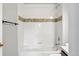 Bathroom with tiled tub and shower, decorative accent tile, and chrome fixtures at 13524 Via Varra, Broomfield, CO 80020