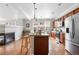 Spacious kitchen with stainless appliances, granite counters, wood cabinets and center island with seating at 13524 Via Varra, Broomfield, CO 80020
