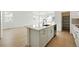 Kitchen island with sink, cabinets, and drawers, set in an open floorplan living space with hardwood floors at 3438 N Duquesne Way, Aurora, CO 80019