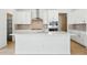 Bright kitchen featuring white cabinets, stainless steel appliances, and a large island with a sink and ample counter space at 3438 N Duquesne Way, Aurora, CO 80019