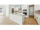 Kitchen featuring white cabinets, an island with sink, stainless steel appliances, and hardwood floors at 3438 N Duquesne Way, Aurora, CO 80019