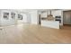 Sunlit open-concept living area with wood-look flooring, flowing seamlessly into the kitchen and dining spaces at 3438 N Duquesne Way, Aurora, CO 80019