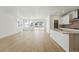 Open-concept living space with wood floors, abundant natural light, and modern kitchen featuring stainless steel appliances at 3438 N Duquesne Way, Aurora, CO 80019