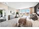 Bright and airy main bedroom featuring a sitting area, three windows and luxury furniture at 3438 N Duquesne Way, Aurora, CO 80019