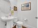 A bathroom with a pedestal sink, wood-look flooring, and neutral colors for a clean and modern look at 3000 E 16Th Ave # 320, Denver, CO 80206