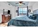 Comfortable bedroom featuring a bed, dresser, ceiling fan, and window at 3000 E 16Th Ave # 320, Denver, CO 80206