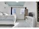 Bright bedroom with two windows, blue ceiling, gray carpet, and white furniture, including a bed and bookshelves at 3000 E 16Th Ave # 320, Denver, CO 80206