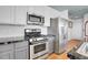 Modern kitchen features stainless steel appliances, white cabinetry, and marble countertops at 3000 E 16Th Ave # 320, Denver, CO 80206