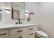 A well-lit half-bath features a sleek white vanity with black fixtures, modern lighting, and a neutral color scheme at 7208 S Xanthia Way, Centennial, CO 80112