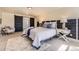 A spacious bedroom features stylish sliding doors, a plush bed with decorative pillows, and a cozy rug on carpet at 7208 S Xanthia Way, Centennial, CO 80112