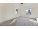 A simple, yet bright bedroom featuring neutral carpet, base molding, and two large, newly trimmed windows at 7208 S Xanthia Way, Centennial, CO 80112