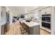 Bright kitchen with white cabinets, stainless steel appliances, and a large center island with barstool seating at 7208 S Xanthia Way, Centennial, CO 80112