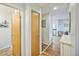 Hallway shows a bathroom, closets, utility box, table and view to the kitchen with wood floors and white trim at 3240 Iris Ave # G409, Boulder, CO 80301
