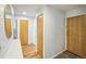 Hallway features a wood door, wooden floors, white walls and trim, plus a mounted oval mirror at 3240 Iris Ave # G409, Boulder, CO 80301