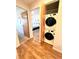 Hallway with wood floors leading to the bedroom and a closet with stacked washer and dryer at 3240 Iris Ave # G409, Boulder, CO 80301