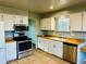 Well-lit kitchen with stainless steel appliances, light countertops, and white cabinets at 4558 S Laredo St, Aurora, CO 80015