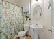 Cozy bathroom with a floral shower curtain, pedestal sink, and decorative wall art at 952 Eaglestone Dr, Castle Rock, CO 80104