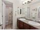 Double sink bathroom with dark wood cabinets, large mirror, and a shower with floral curtain at 952 Eaglestone Dr, Castle Rock, CO 80104