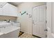 Well-organized laundry room with white cabinetry, utility sink, and modern washer and dryer units at 952 Eaglestone Dr, Castle Rock, CO 80104