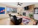 Cozy living room with a stone fireplace, hardwood floors, ceiling fan, and large bright window at 952 Eaglestone Dr, Castle Rock, CO 80104