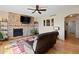 Living room with stone fireplace, mounted television, ceiling fan, and hardwood floors at 952 Eaglestone Dr, Castle Rock, CO 80104