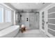 Bathroom featuring a freestanding tub, large glass enclosed shower, and double doors at 12092 S Great Plain Ct, Parker, CO 80134