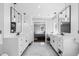 Bright bathroom with dual sink vanity, dark fixtures, and a glass enclosed shower at 12092 S Great Plain Ct, Parker, CO 80134