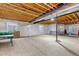 Unfinished basement with exposed ceiling, two windows, and concrete flooring at 16122 Emporia Way, Brighton, CO 80602