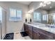 Bathroom featuring double vanity with granite counters, a shower, and natural light at 16122 Emporia Way, Brighton, CO 80602