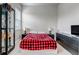 Bedroom featuring a bed with red plaid blanket, display case, and soft natural light at 16122 Emporia Way, Brighton, CO 80602