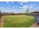 Backyard featuring a large grass area, a wooden fence, and some shrubbery at 9625 Bighorn Way, Littleton, CO 80125