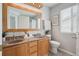 Bright bathroom with a double sink vanity, light wood cabinets and a framed mirror at 9625 Bighorn Way, Littleton, CO 80125