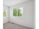This bright bedroom features neutral carpet and a view of mature trees at 9625 Bighorn Way, Littleton, CO 80125