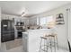 Modern kitchen features stainless appliances, gray cabinetry, quartz countertops, and a convenient breakfast bar at 9625 Bighorn Way, Littleton, CO 80125