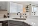 Modern kitchen features gray cabinetry, quartz countertops, stainless sink, and decor at 9625 Bighorn Way, Littleton, CO 80125
